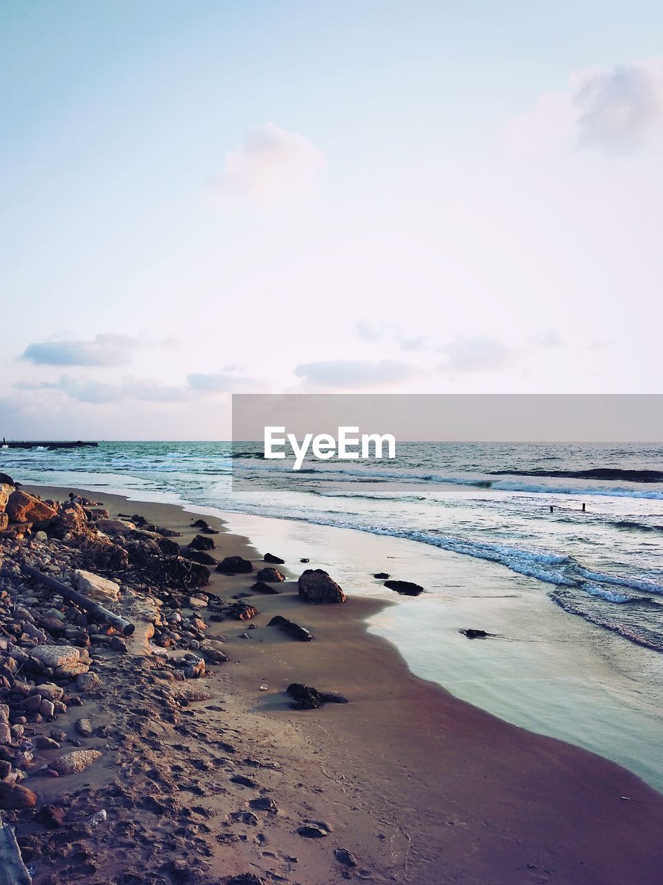 SCENIC VIEW OF ROCKS ON BEACH AGAINST SKY