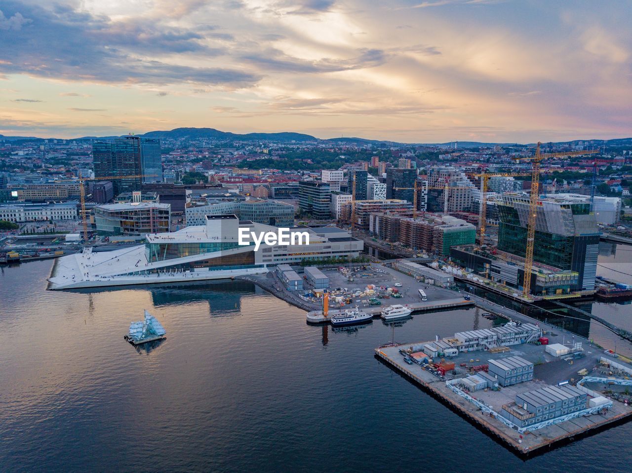 High angle view of river and buildings against sky during sunset