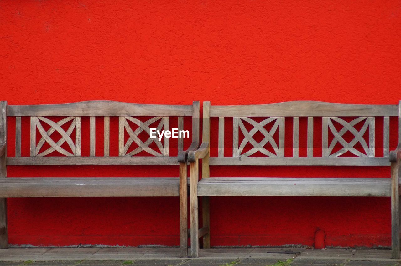 EMPTY CHAIRS AGAINST RED WALL