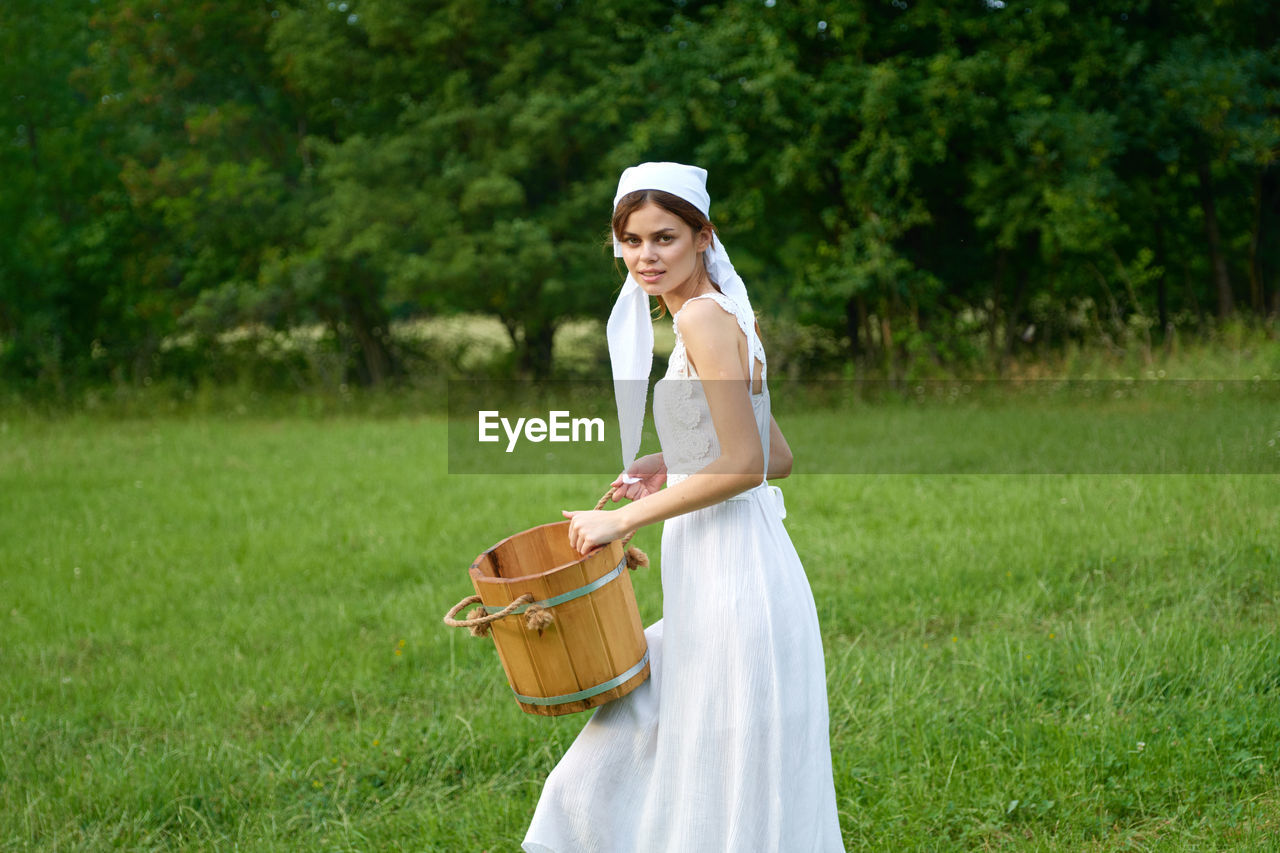 full length of young woman standing on field