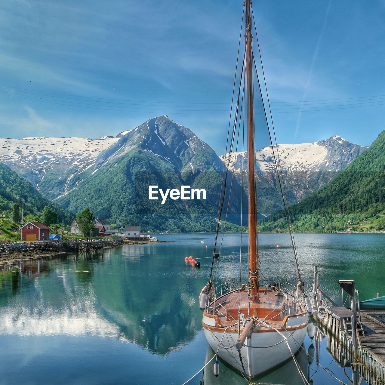 SAILBOATS MOORED IN LAKE AGAINST SKY