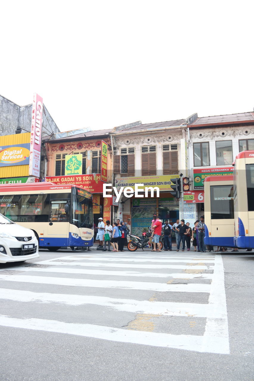 VEHICLES ON ROAD AGAINST BUILDINGS