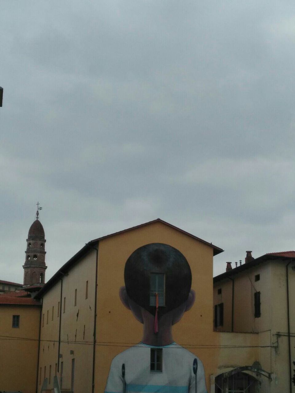 Mural on house wall against cloudy sky