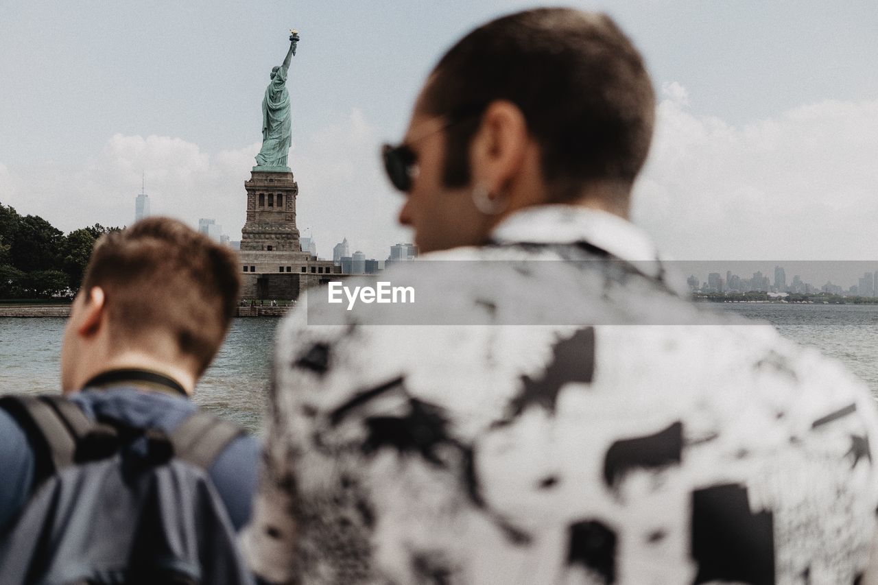 Rear view of man against statue of liberty