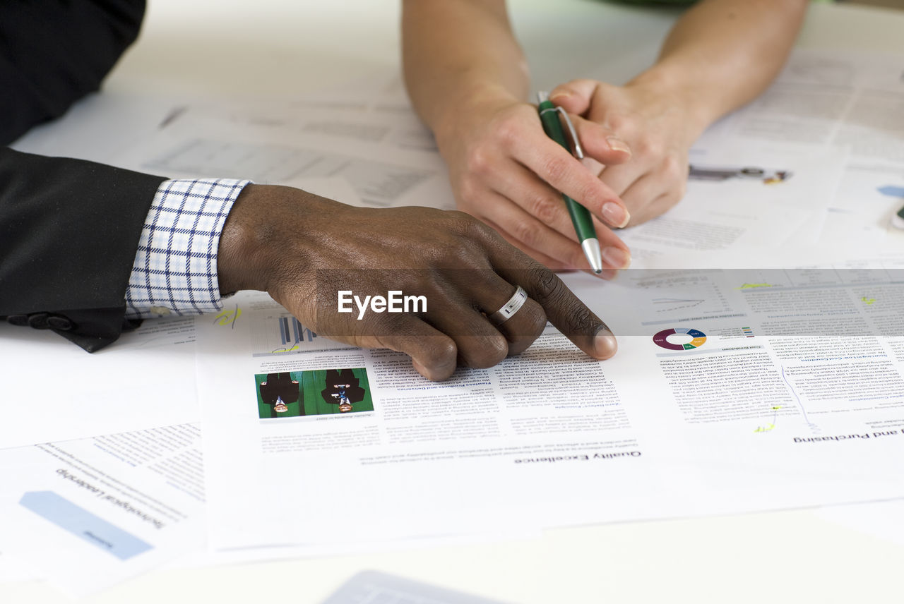 Close-up of hands on coworkers on document