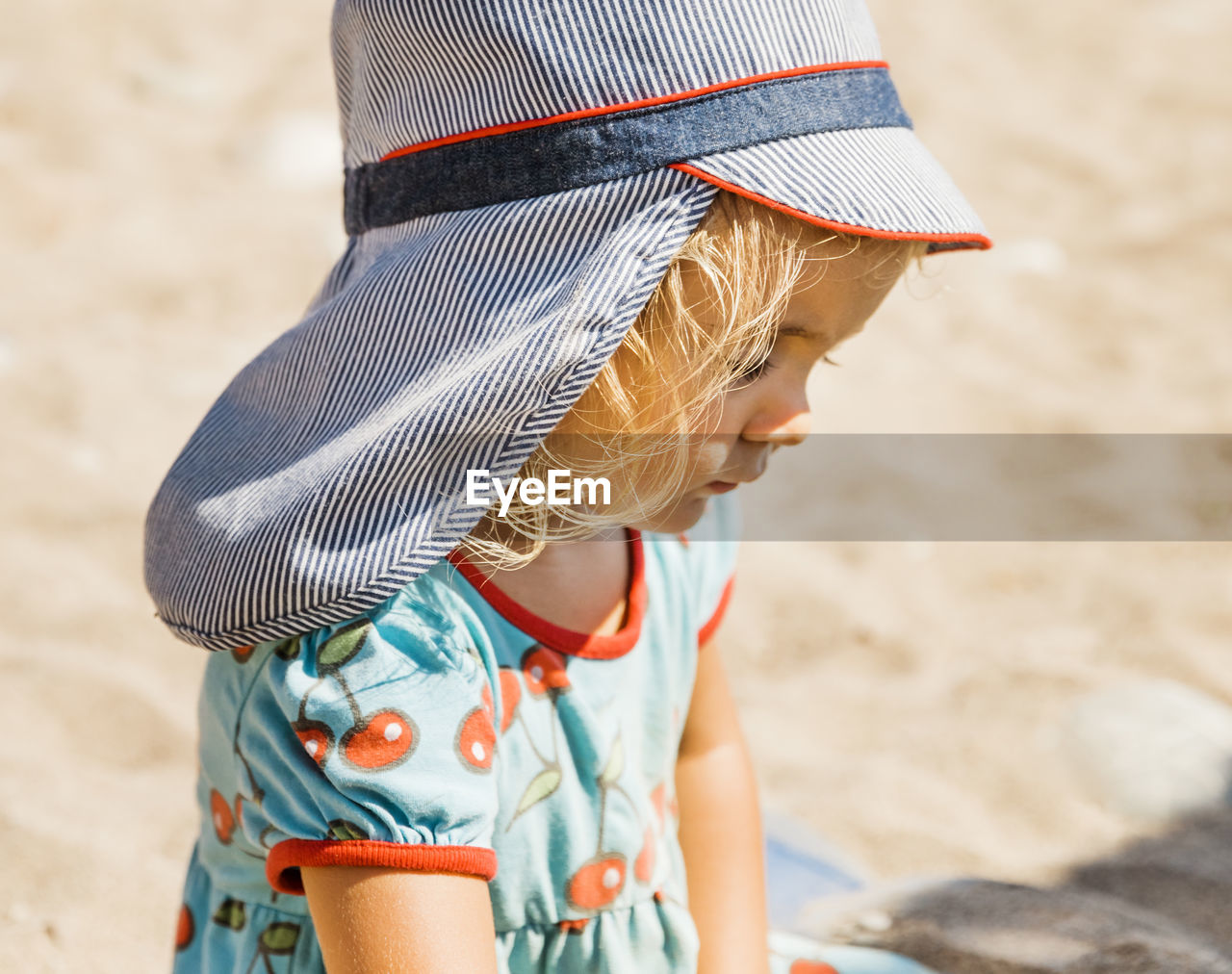 Midsection of girl wearing hat on sand