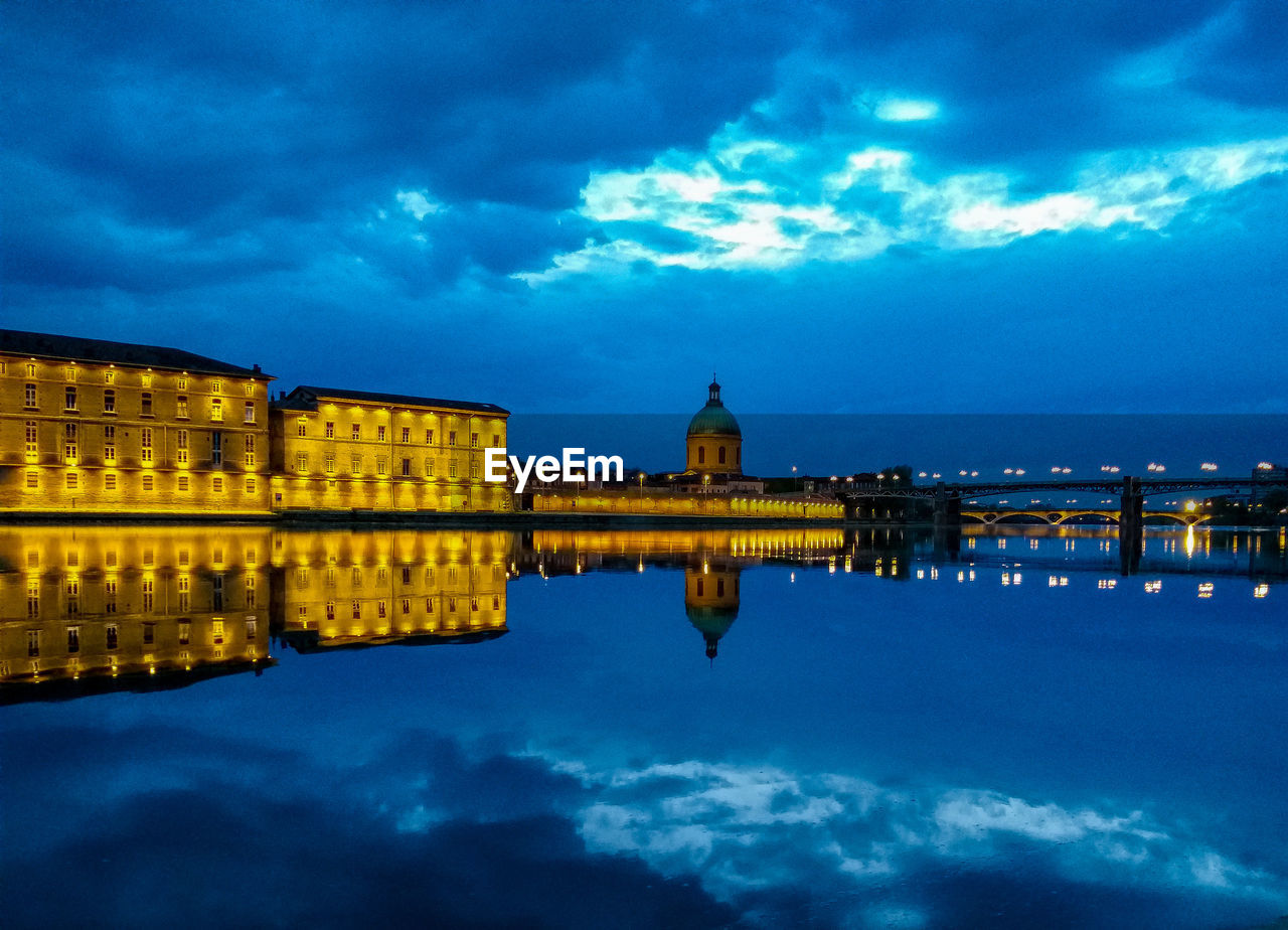 Illuminated city against sky at dusk