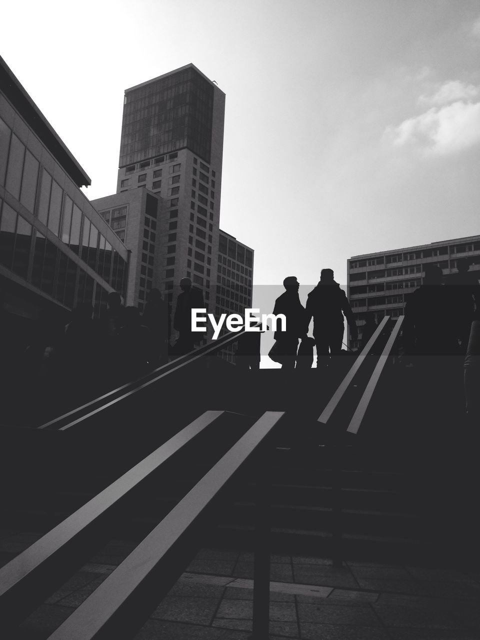 Low angle view of people walking up stairs against buildings