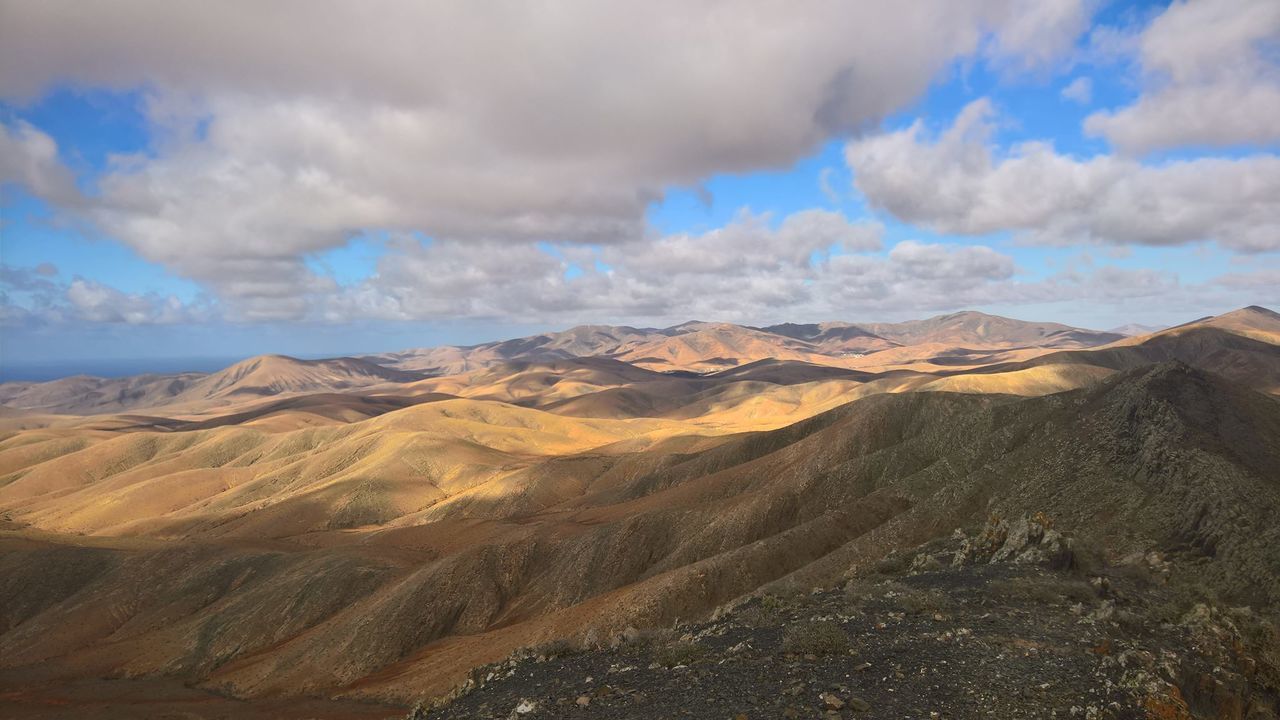 Scenic view of mountains against cloudy sky