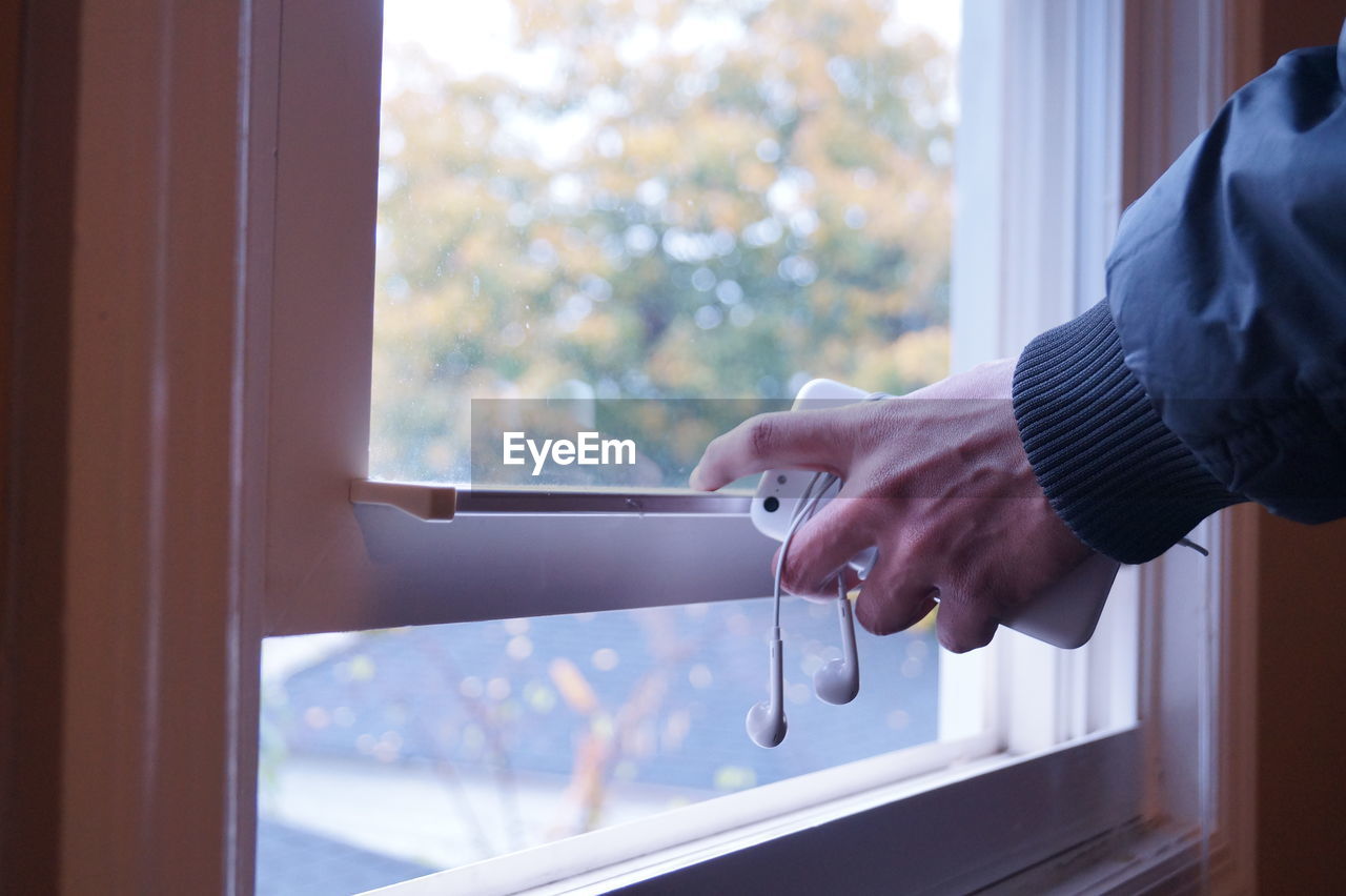 CLOSE-UP OF MAN HOLDING WINDOW