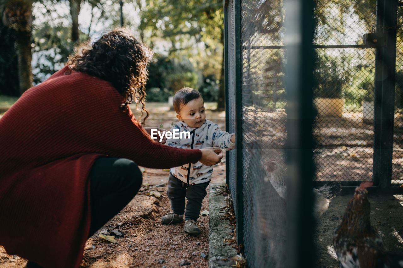 Mother and child feeding chickens