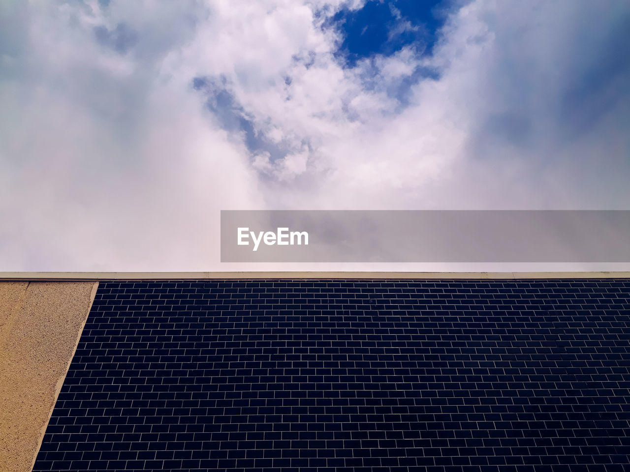 LOW ANGLE VIEW OF ROOF OF BUILDING AGAINST CLOUDY SKY