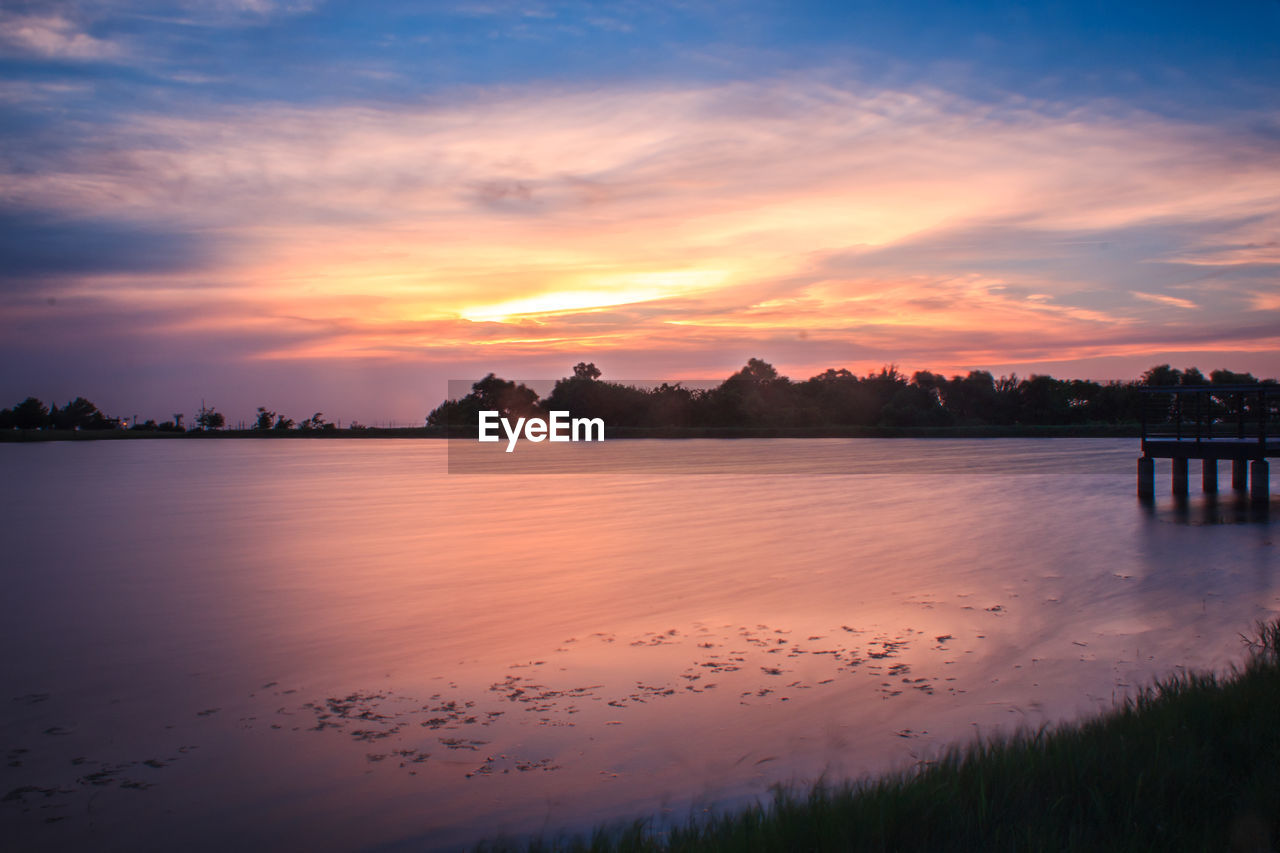 SCENIC VIEW OF LAKE AGAINST SUNSET SKY