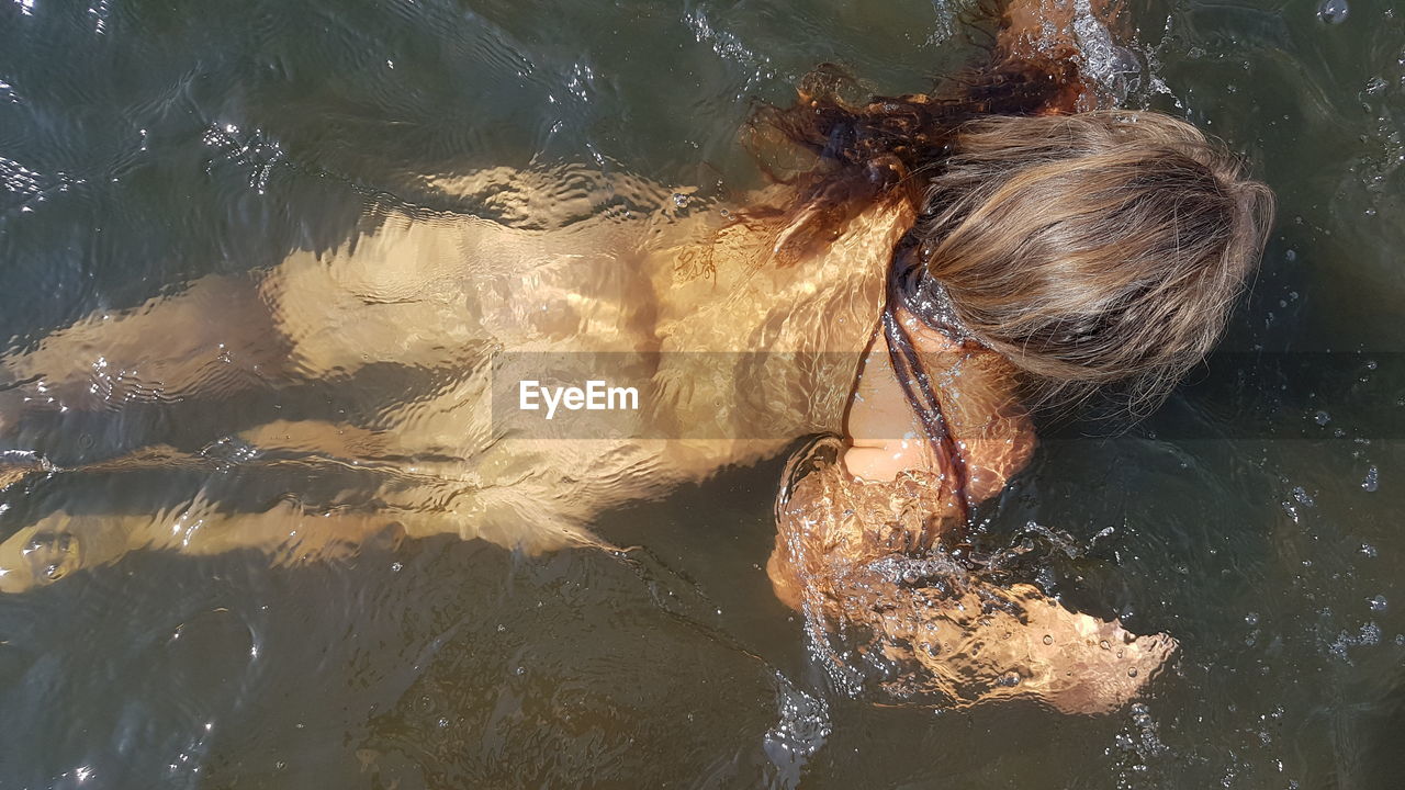 PORTRAIT OF WOMAN SWIMMING IN SEA