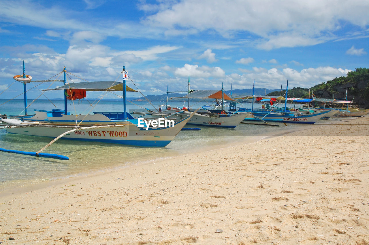 VIEW OF BOATS MOORED ON SHORE AGAINST SKY