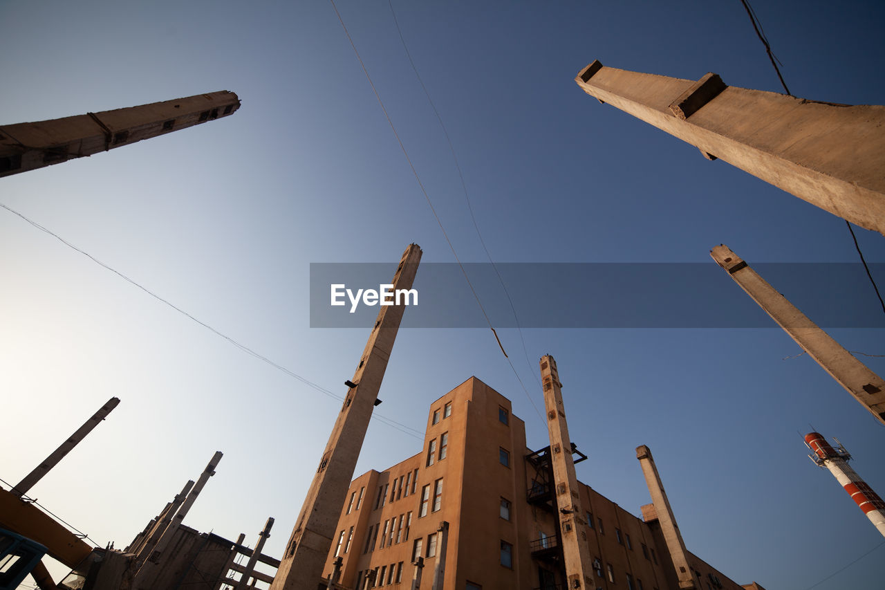 sky, architecture, industry, nature, nautical vessel, low angle view, mast, clear sky, built structure, no people, transportation, outdoors, business, ship, construction industry, vehicle, blue, business finance and industry, building exterior, water, city, crane - construction machinery