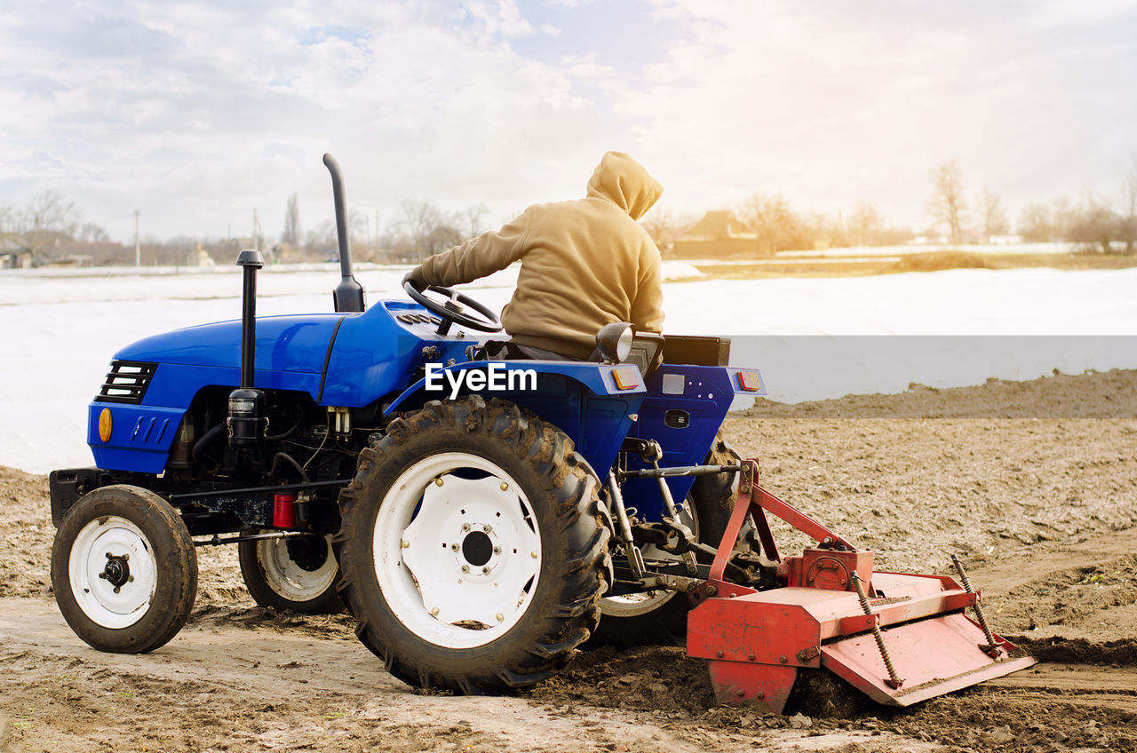 Farmer on a tractor with milling machine loosens, grinds and mixes soil. loosening the surface