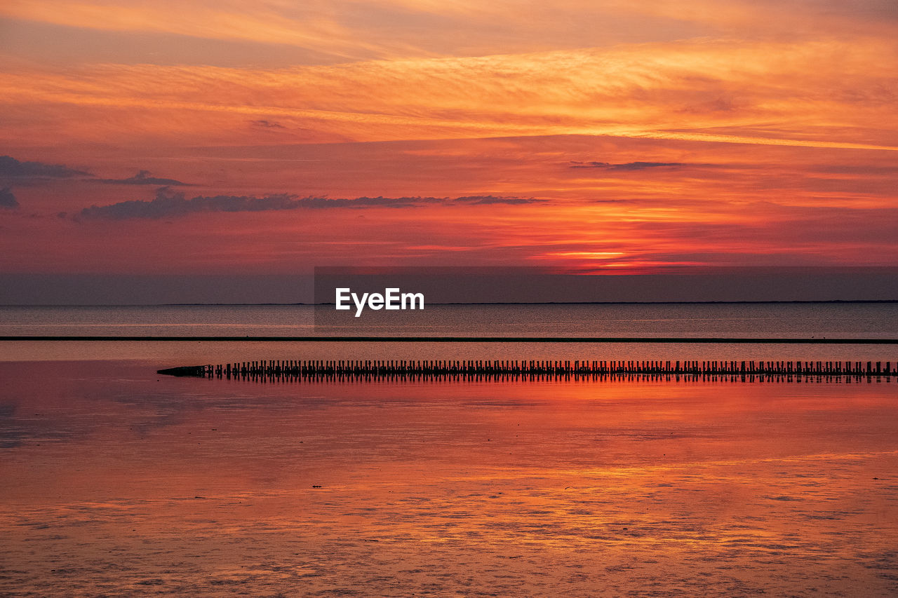 Scenic view of sea against orange sky