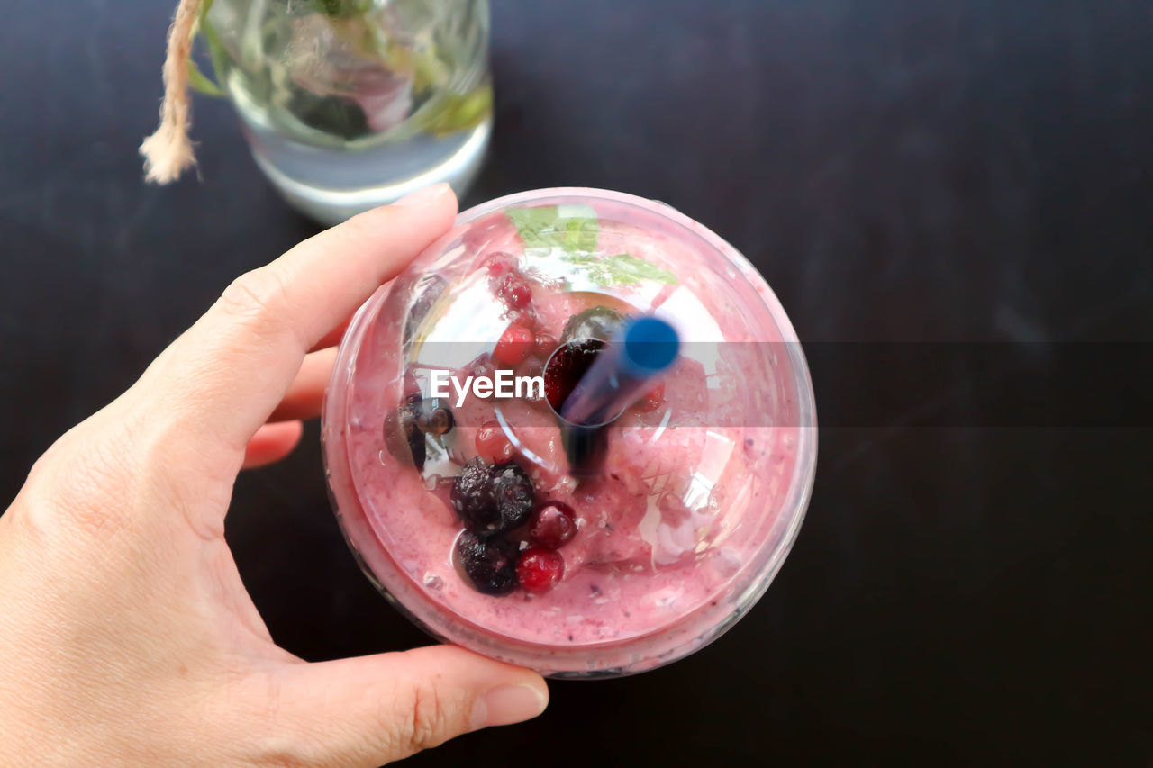 CLOSE-UP OF PERSON HOLDING ICE CREAM IN GLASS