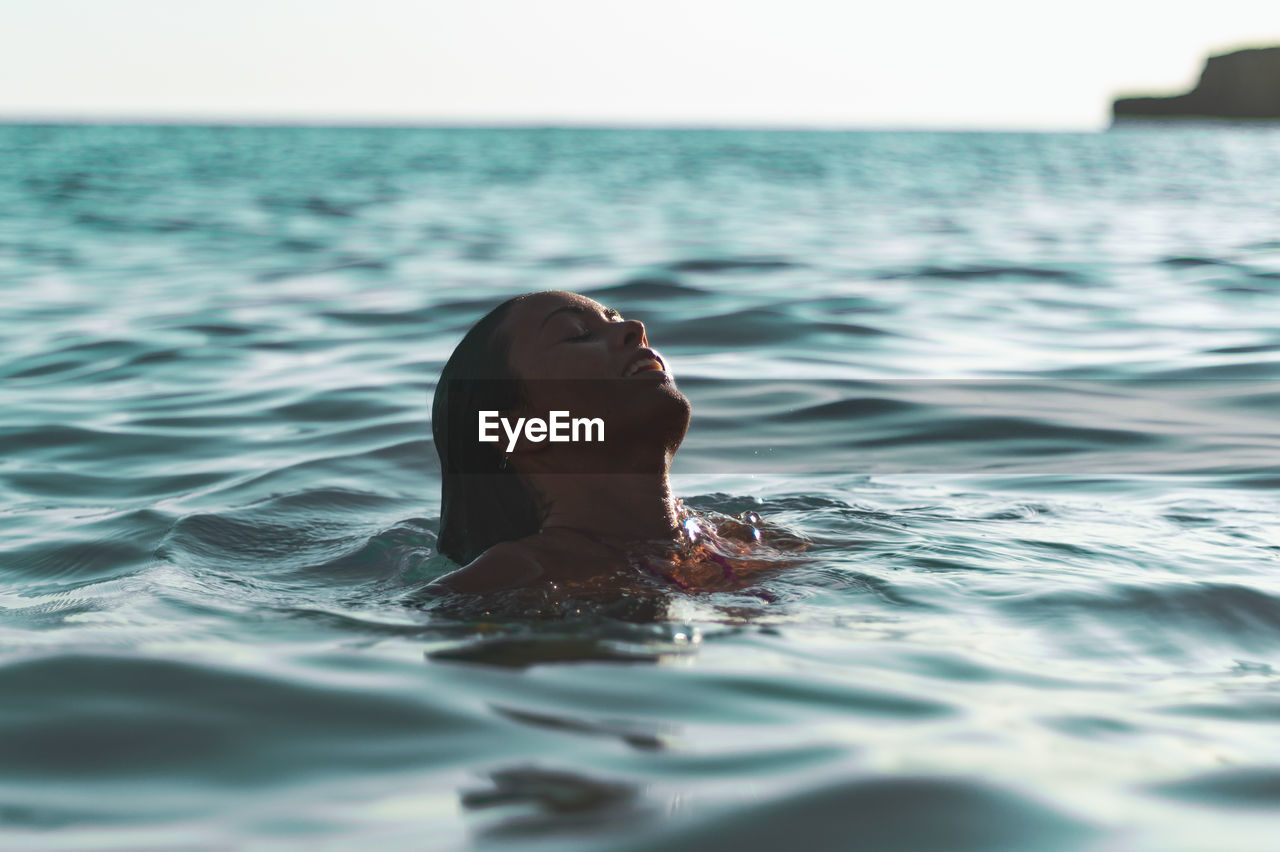 Close-up of woman on water surface of sea