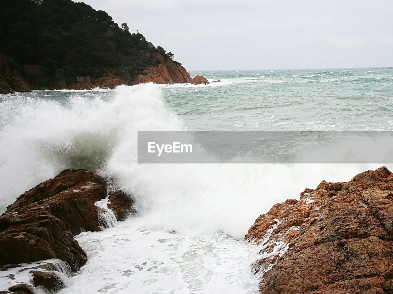 Scenic view of sea waves splashing against sky