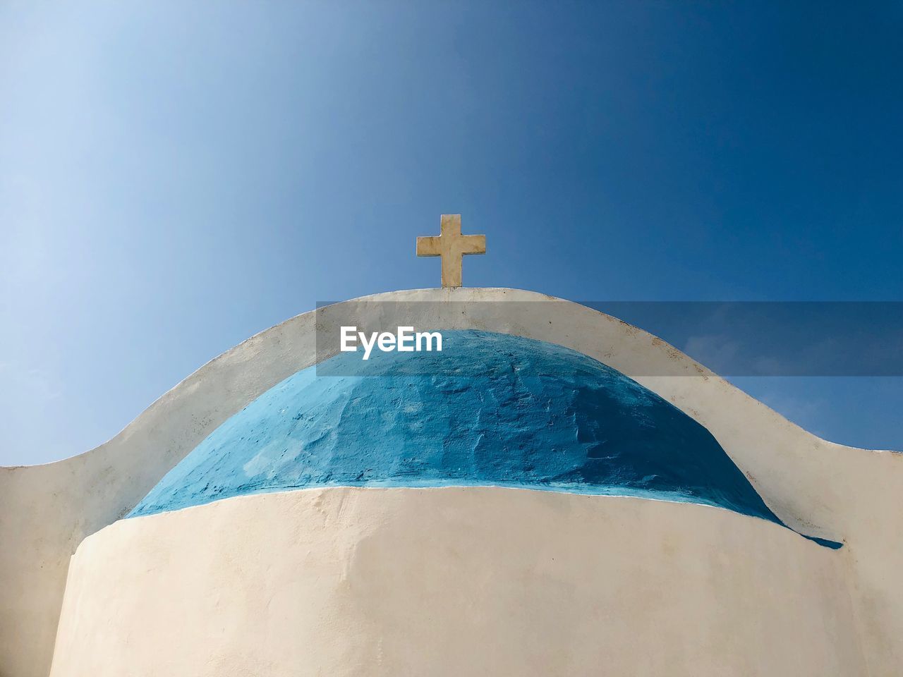 Low angle view of cross on church against blue sky