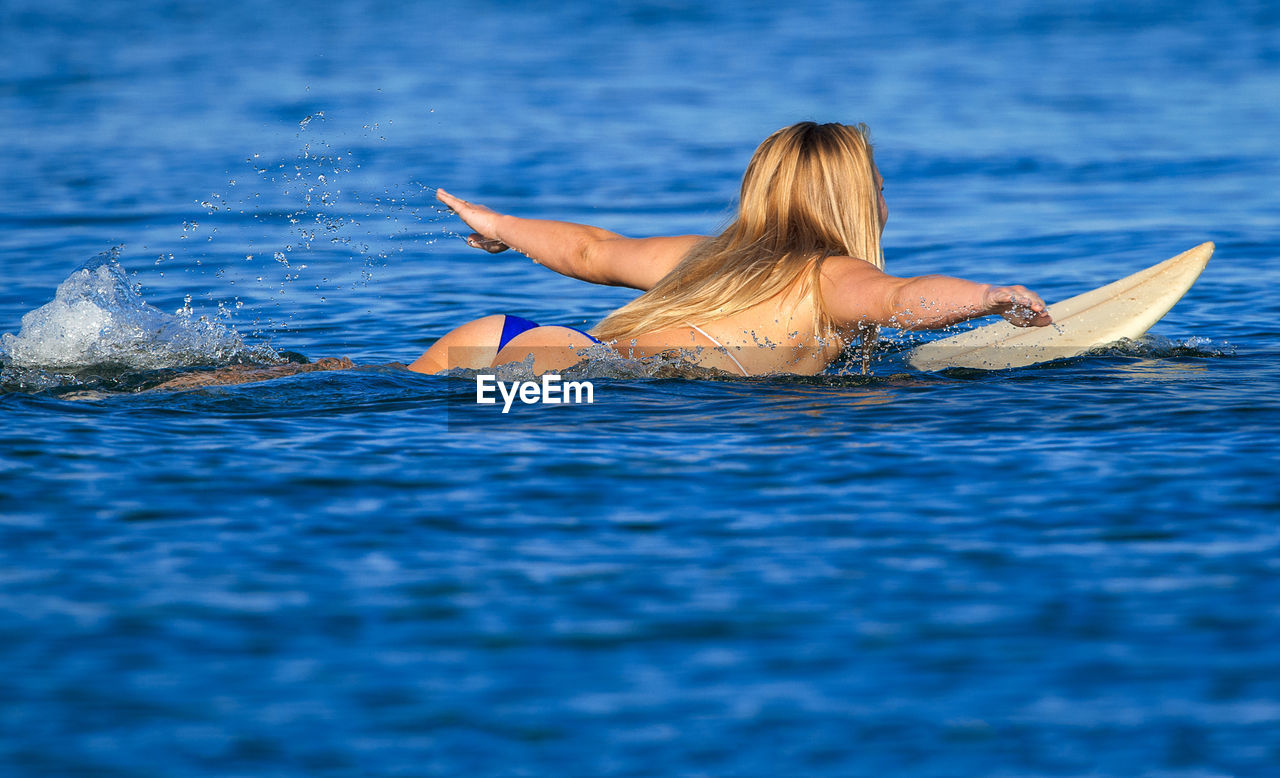 MAN SWIMMING IN POOL AGAINST BLUE SKY