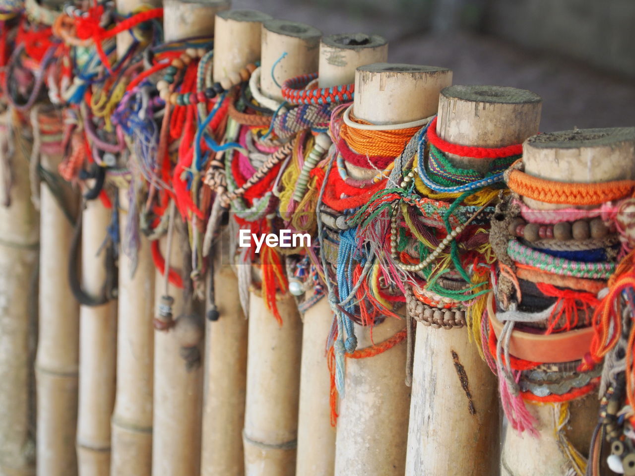 Close-up of multi colored objects tied on bamboos