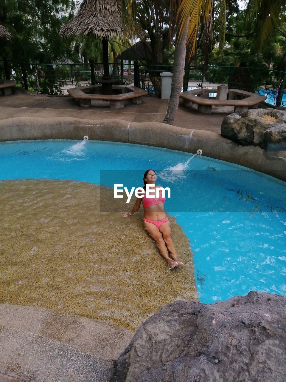 MAN IN SWIMMING POOL BY TREES