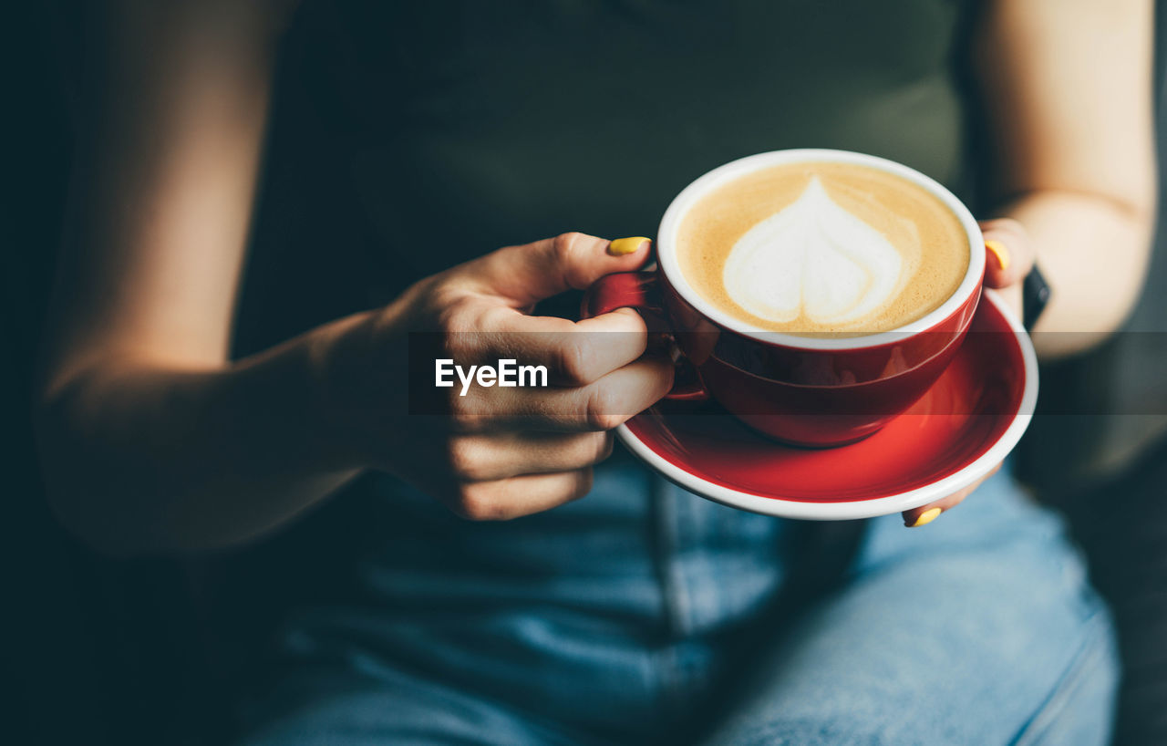 midsection of man holding coffee