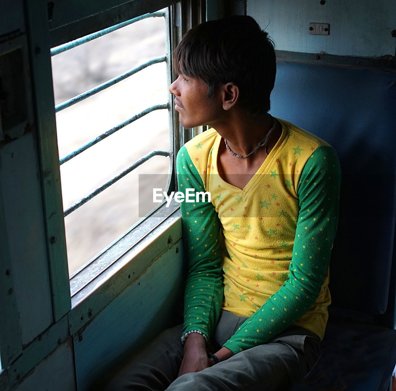 WOMAN SITTING ON WINDOW