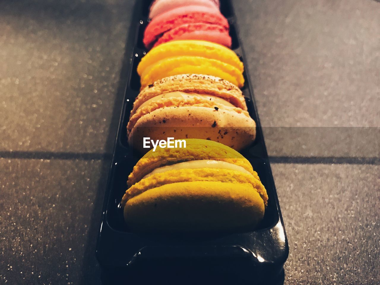 High angle view of multi colored macaroons in box on table