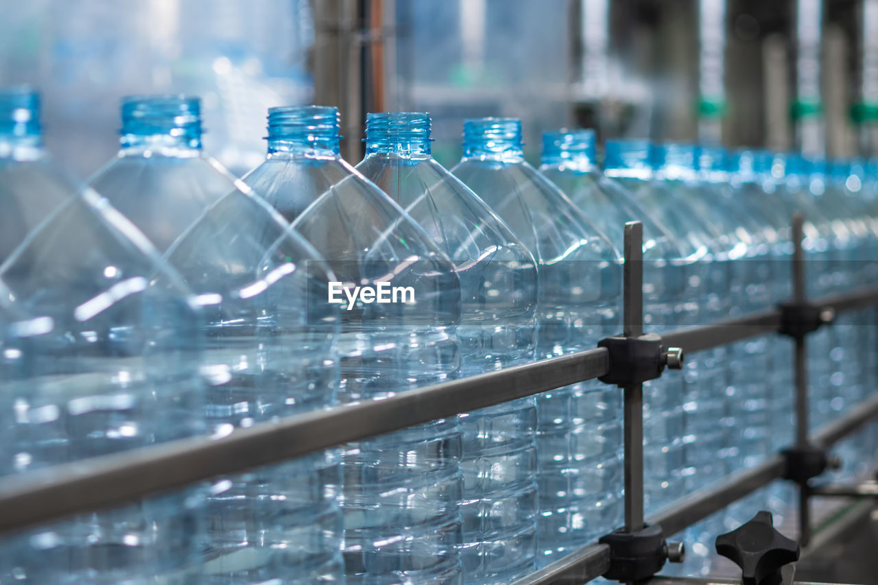 Empty blue five-liter plastic bottles on a conveyor belt. automated production of drinking water