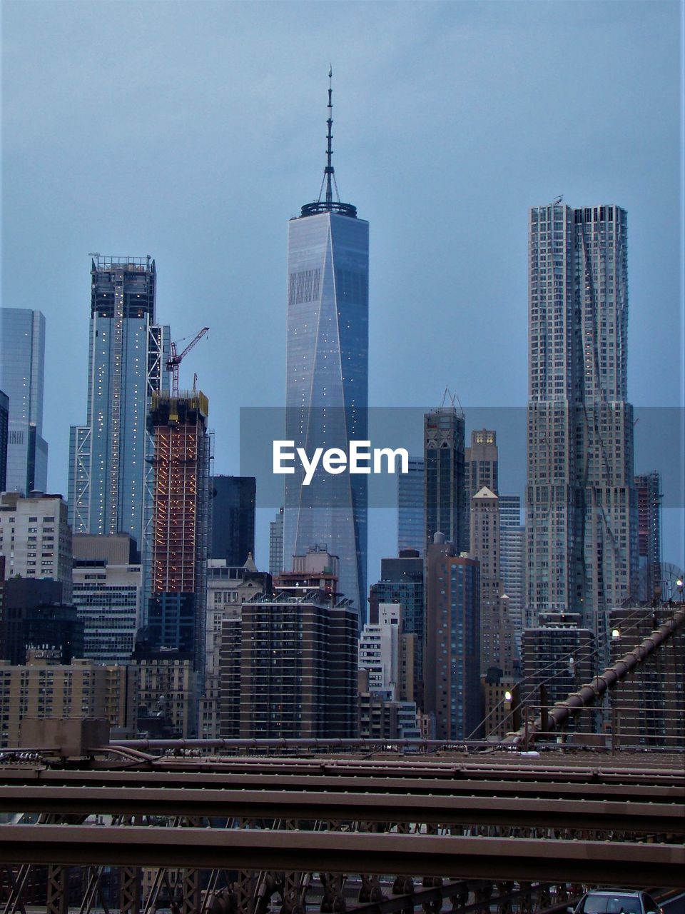 One world trade center in city against sky at dusk