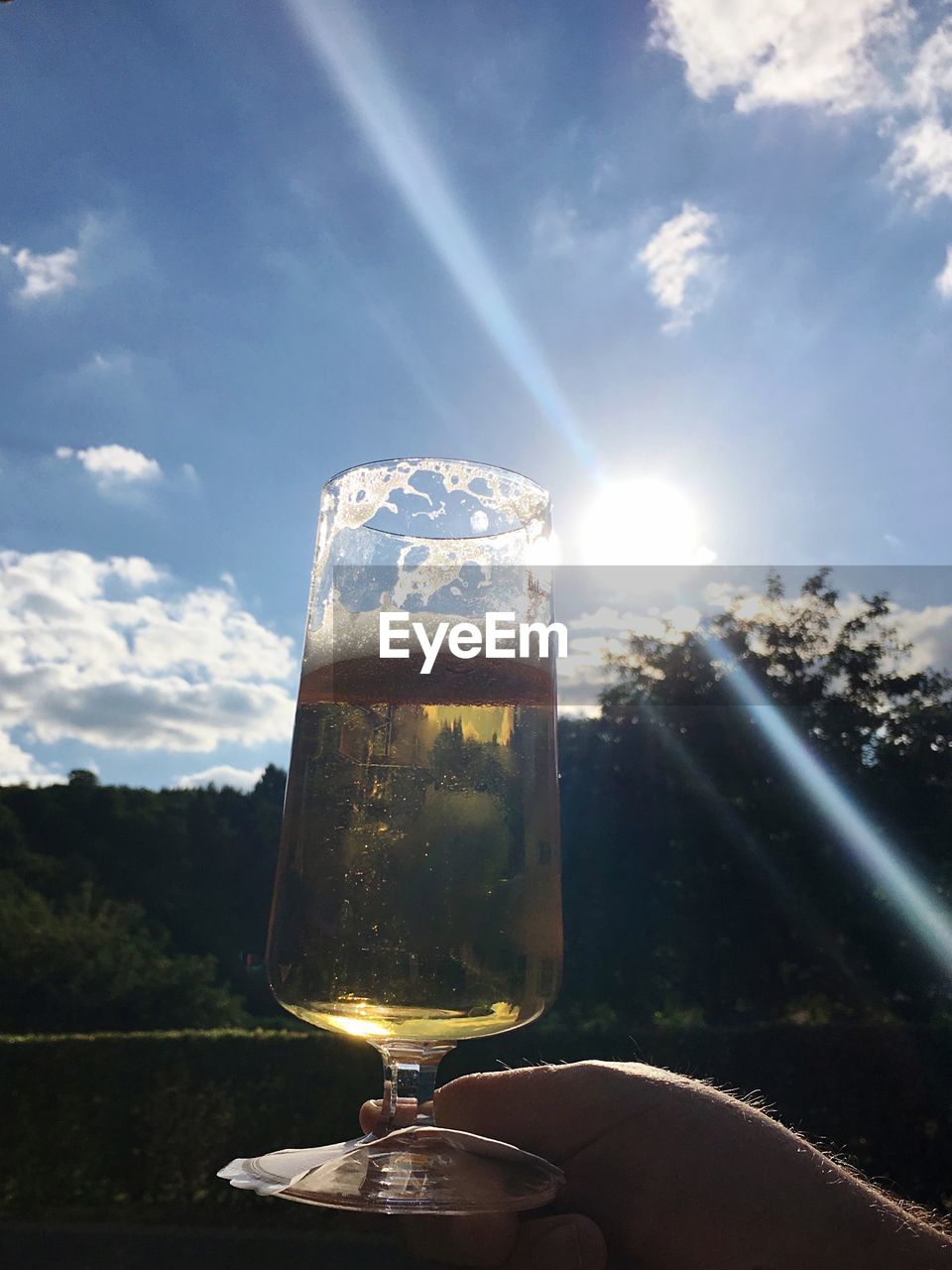 CLOSE-UP OF HAND HOLDING BEER GLASS