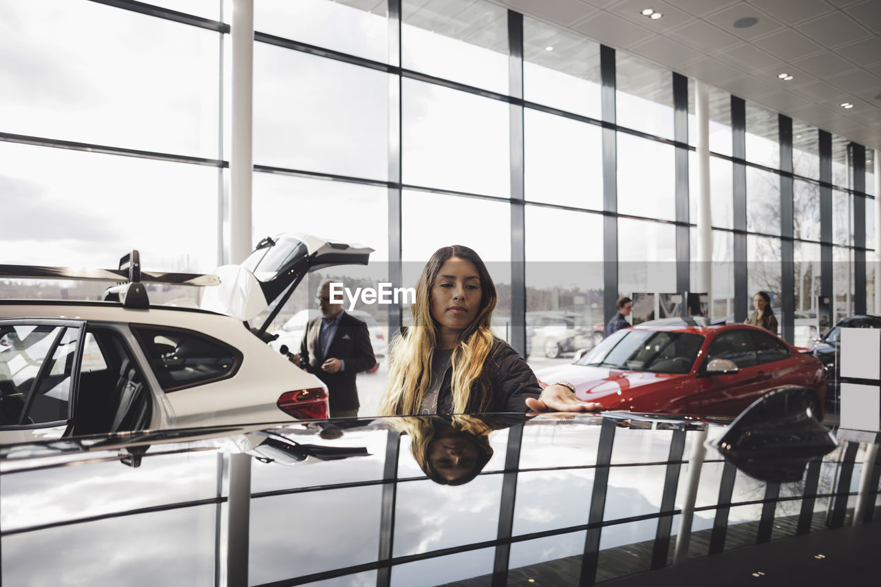 Customers looking at cars in showroom