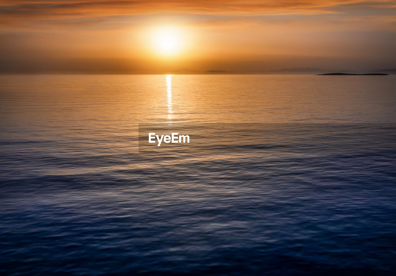 SCENIC VIEW OF SEA AGAINST SKY AT SUNSET