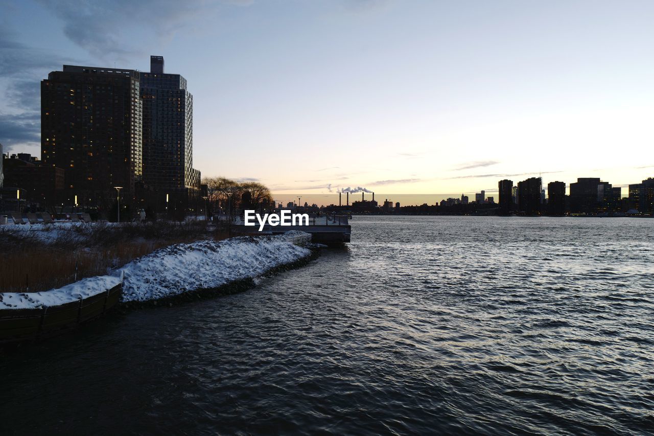 CITY AT WATERFRONT DURING SUNSET