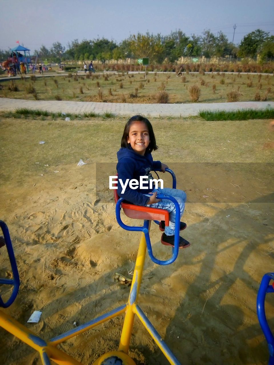 PORTRAIT OF A SMILING GIRL STANDING ON LANDSCAPE