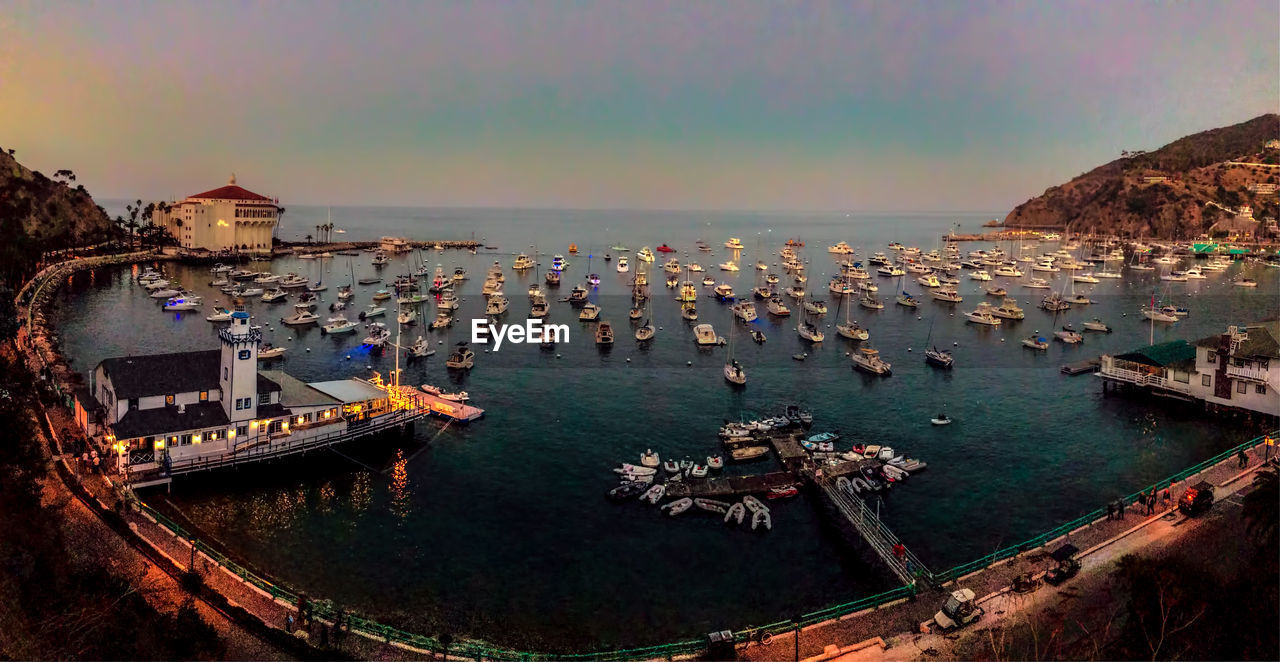 Panoramic view of boats moored in sea against clear sky