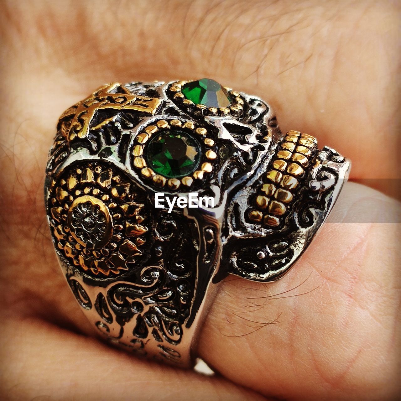 CLOSE-UP OF HUMAN HAND HOLDING METAL RING ON FINGER