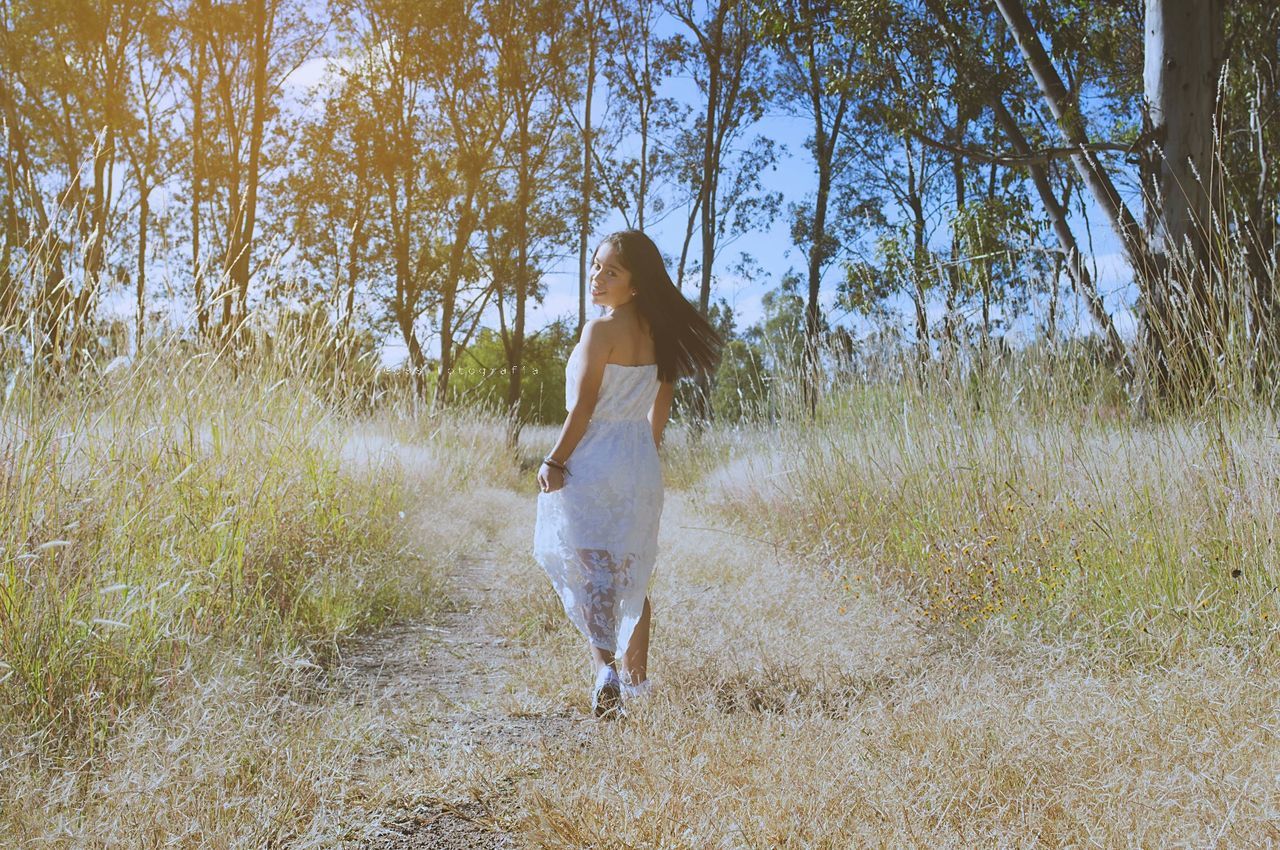 REAR VIEW OF WOMAN WITH UMBRELLA WALKING IN PARK