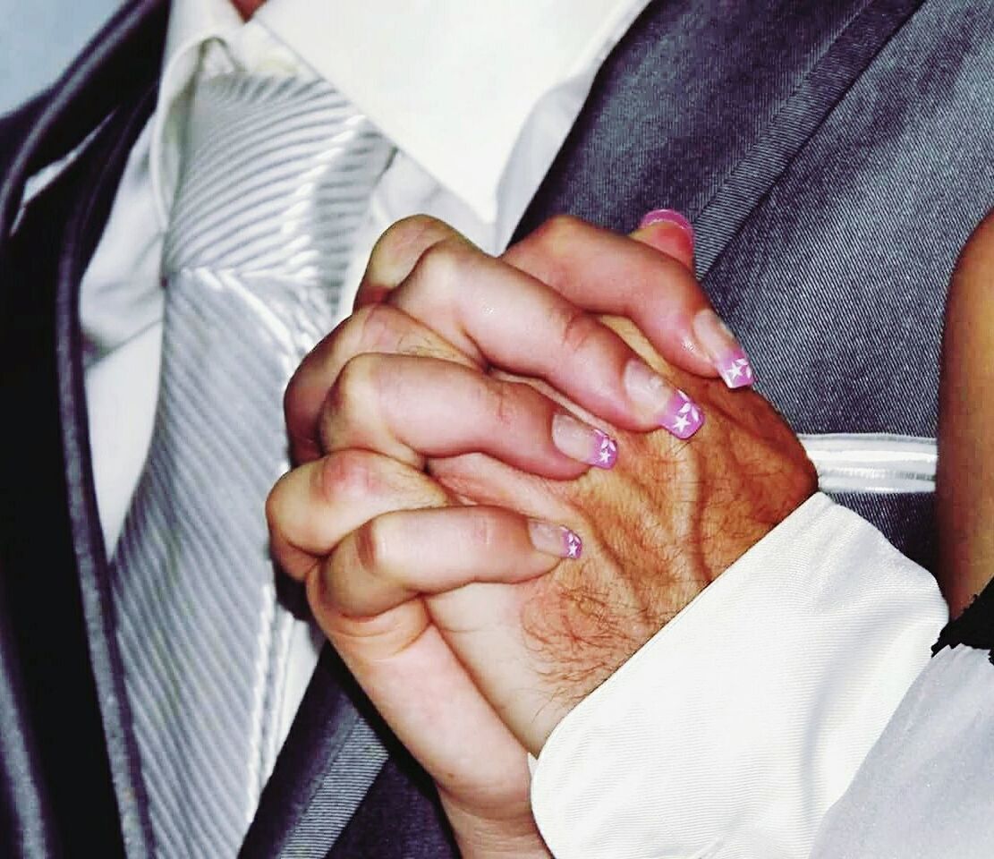 CLOSE-UP OF COUPLE HOLDING HANDS ON CUTTING BOARD