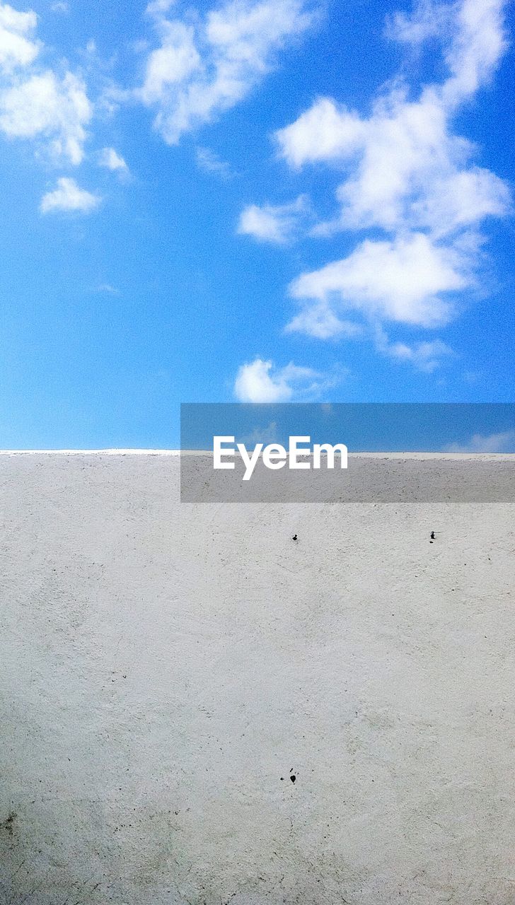 Scenic view of beach against blue sky