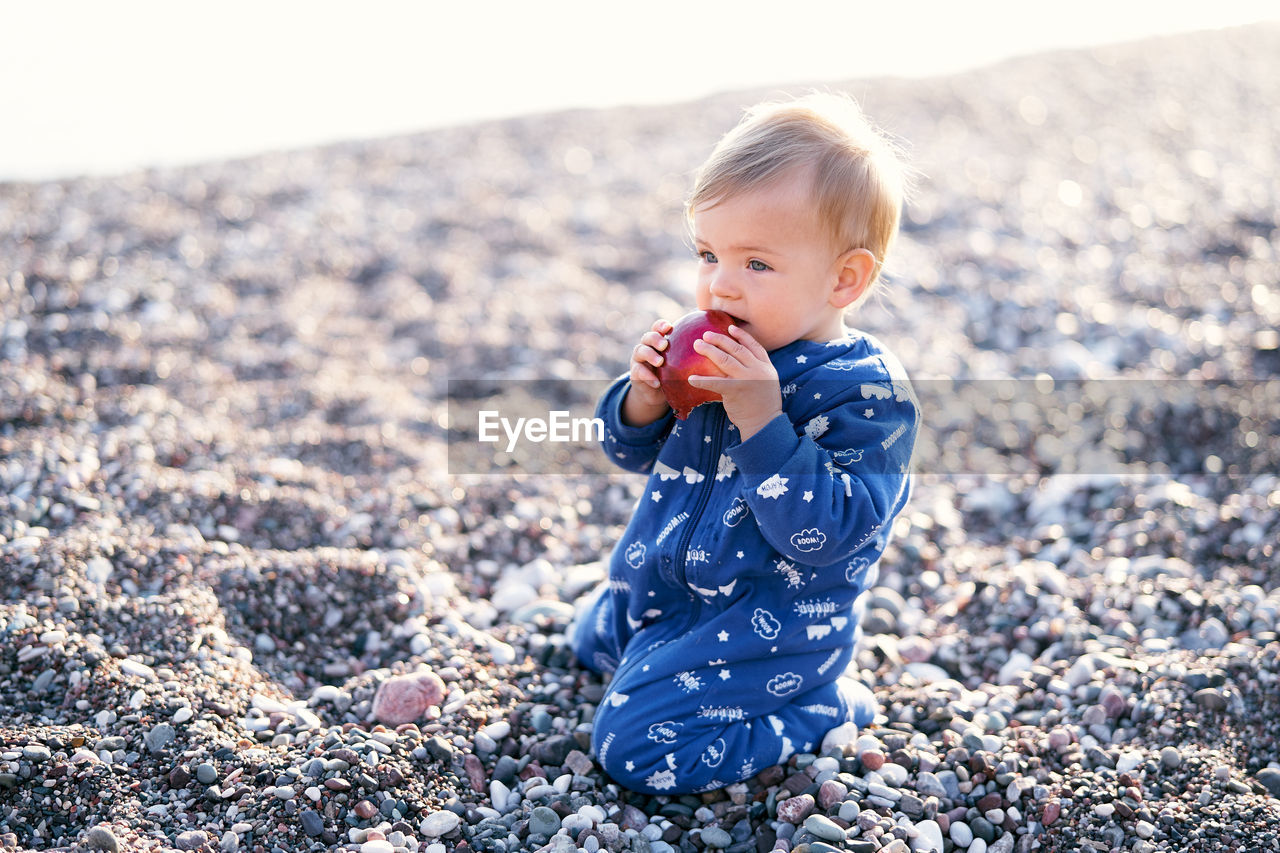 PORTRAIT OF CUTE GIRL ON PEBBLES