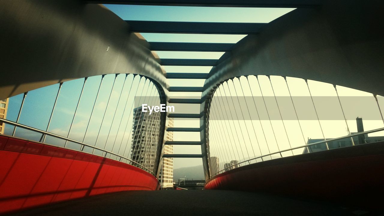 Low angle view of bridge and building in city against sky