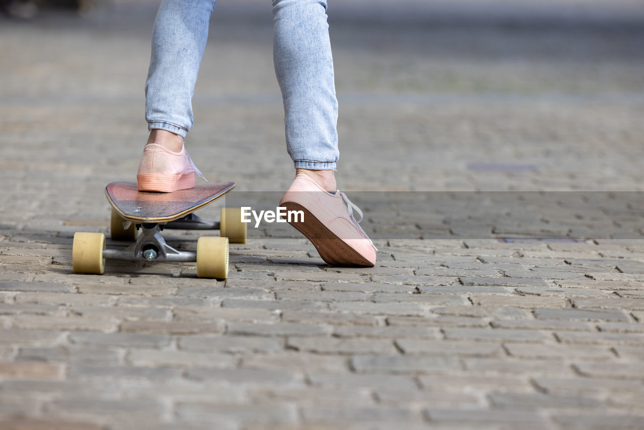 LOW SECTION OF PERSON ON SKATEBOARD