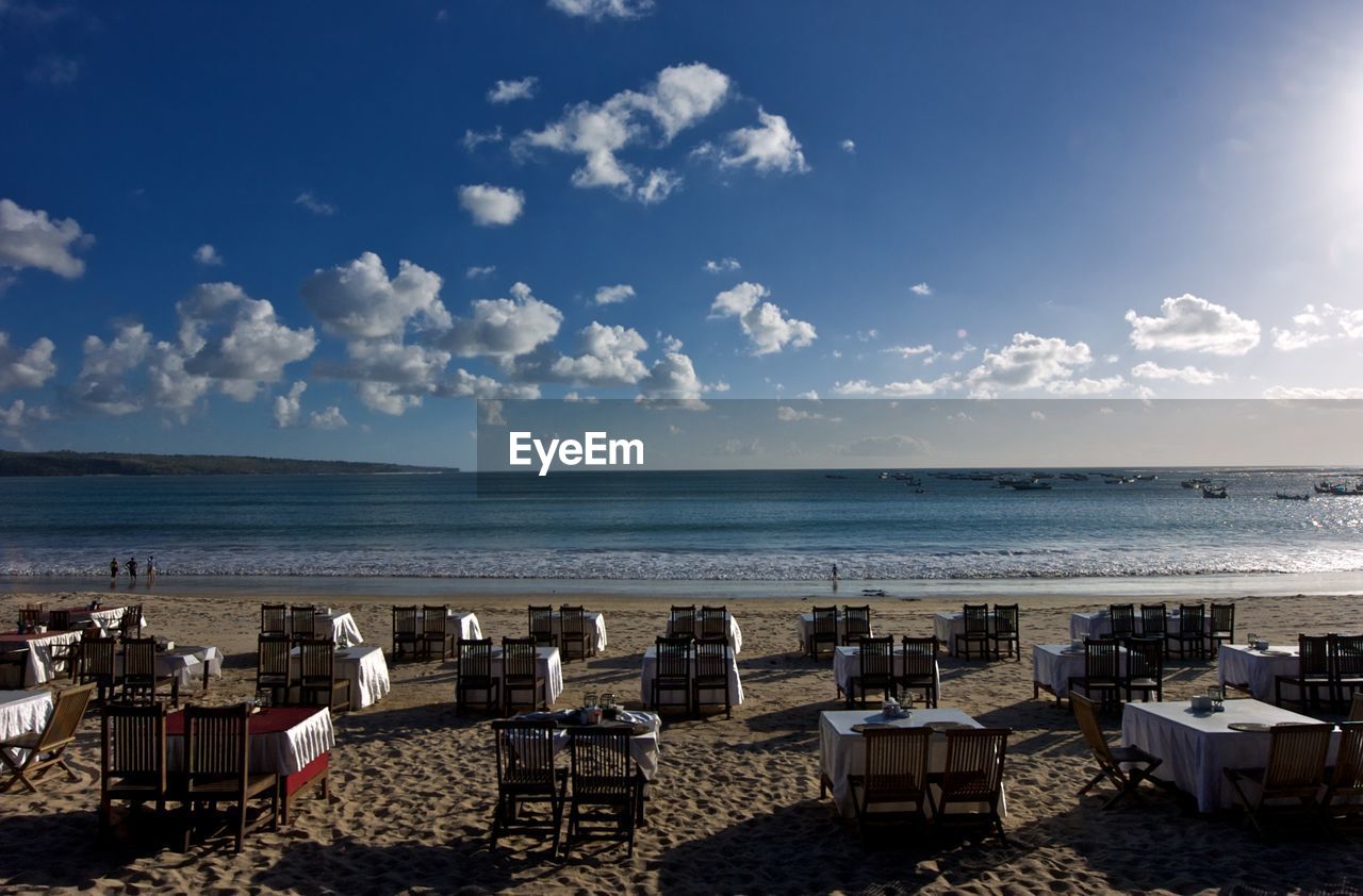 Tables and chairs arranged at beach