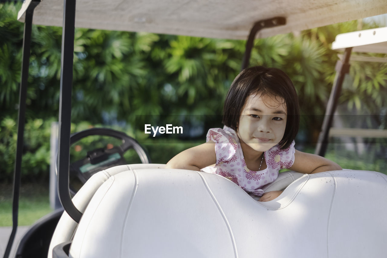 Portrait of smiling girl on golf cart