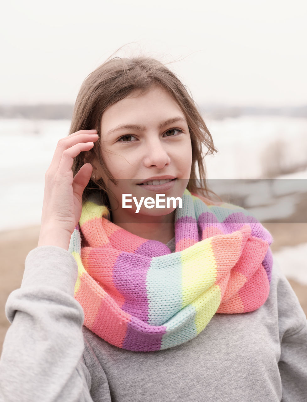 Beautiful teenager girl wearing festive multicolored scarf and looking at camera. outdoors walking.